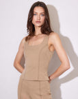 Woman wearing a beige Kali Saddle Stitch Vest with sleeveless design and u-shape neckline featuring saddle stitch detail and side zip closure.