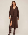 Woman wearing Brielle Midi Skirt in brown cupro fabric with side slit and elastic waist paired with matching top and brown boots