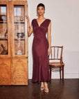 Woman wearing a sleeveless burgundy Cierra Ruffle Detail midi dress with V-neckline and under bust ruffle detail.