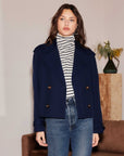 Woman wearing Abbey Turtleneck Tank with off white and black stripes under navy blazer and jeans
