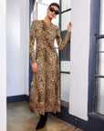 Woman wearing Kourtney Cross-Front Midi Dress in bold animal print with long sleeves and crossover neckline