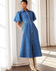 Esme Denim Midi Dress with puff sleeves, pointed collar, snap-button front, and side pockets in stretch denim