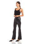 Woman wearing black Finley Wide-Leg Pants made of soft faux leather with a high waist and full length design.