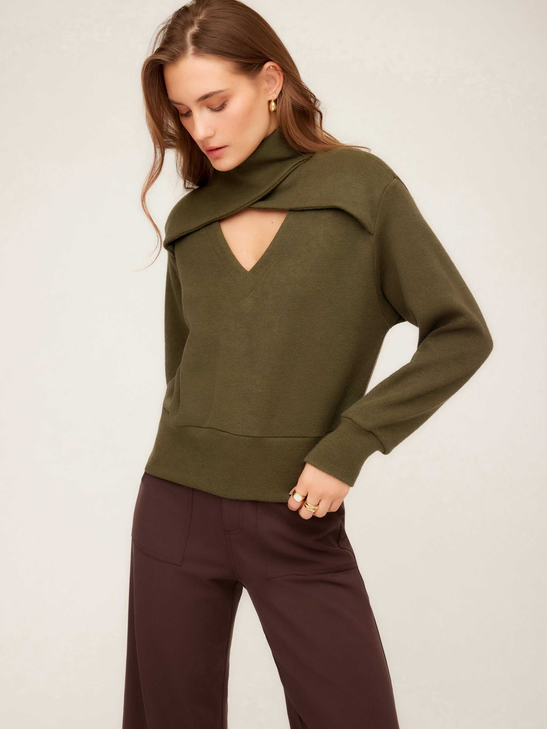 Woman wearing olive green Caly Turtleneck Sweater with built-in scarf detail and deep V-neckline.