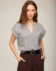Woman wearing gray Morgan V-Neck Top with short sleeves and split neckline tucked into dark pants