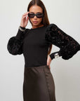 Kaya Contrast Bishop Sleeve Top in black, with a smooth fitted body, sheer floral burnout velvet bishop sleeves, and a crew neckline.