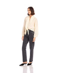 Woman wearing a Capri Tie-Front Blouse in cream cupro fabric paired with high-waisted black jeans and black shoes