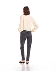 Woman wearing a cream Capri Tie-Front Blouse with long blouson sleeves and elasticized cuffs paired with dark high-waisted jeans, shown from the back.