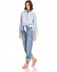 Woman wearing light blue Capri Tie-Front Blouse with long sleeves and denim jeans