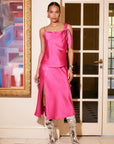 Model wearing a pink Brielle Midi Skirt with side slit and matching Sasha tank top in a stylish indoor setting