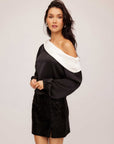 Woman wearing Marisa One-Shoulder Top in black and white satin with long blouson sleeves and elasticized cuffs.
