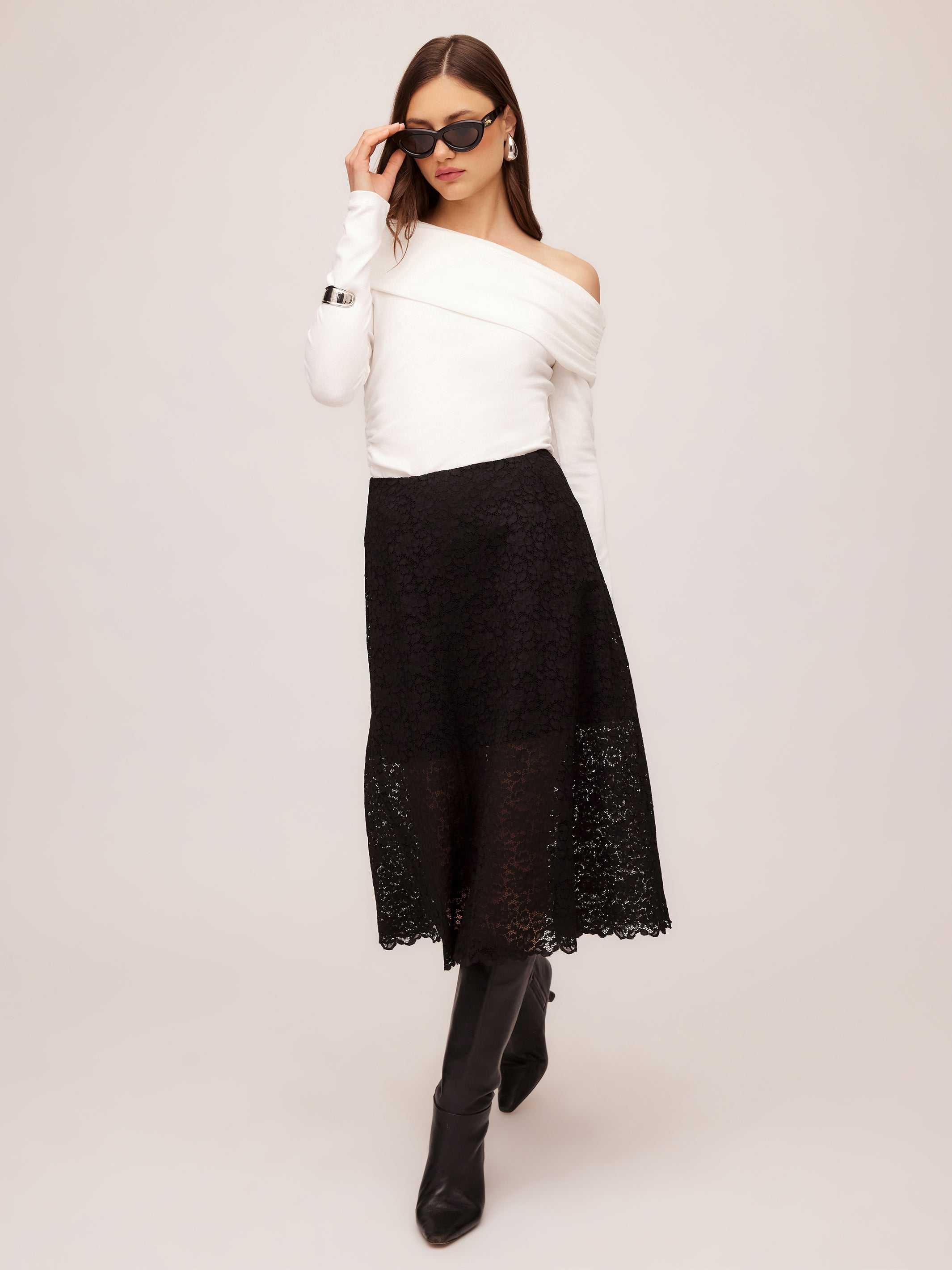 Woman wearing black Millie A-Line Skirt with scalloped stretch lace and white off-shoulder top