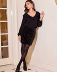 Woman wearing black Lola Mini Skirt with sequin stretch velvet and pencil silhouette with side slit