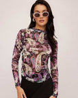 Woman wearing Khami Shirred Top with colorful Italian paisley print, long sleeves, and sheer breathable mesh fabric.
