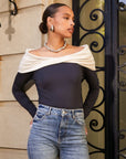 Woman wearing Jillian Off-The-Shoulder Top with twist neck and side shirring in black and cream paired with jeans