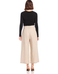 Woman wearing beige pinstripe linen Sadie Trousers with wide leg and cropped length, paired with black long-sleeve top.