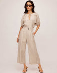 Woman wearing beige pinstripe linen Sadie Trousers with wide leg cropped style and front pleats.