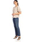 Woman wearing beige Imogen Poof Sleeve Top with pinstripe linen and blue jeans.
