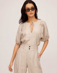 Woman wearing Imogen Poof Sleeve Top in lightweight pinstripe linen with split neck tie and short elasticized sleeves