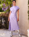 Woman wearing lavender Brielle midi skirt with side slit and matching top outdoors
