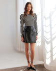 Britney Faux Patent Leather mini skirt with glossy finish and front flap pockets worn by model