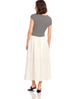 Woman wearing Contrast Hem Sylvie Dress with black and white striped jersey top and solid white skirt, viewed from the back.
