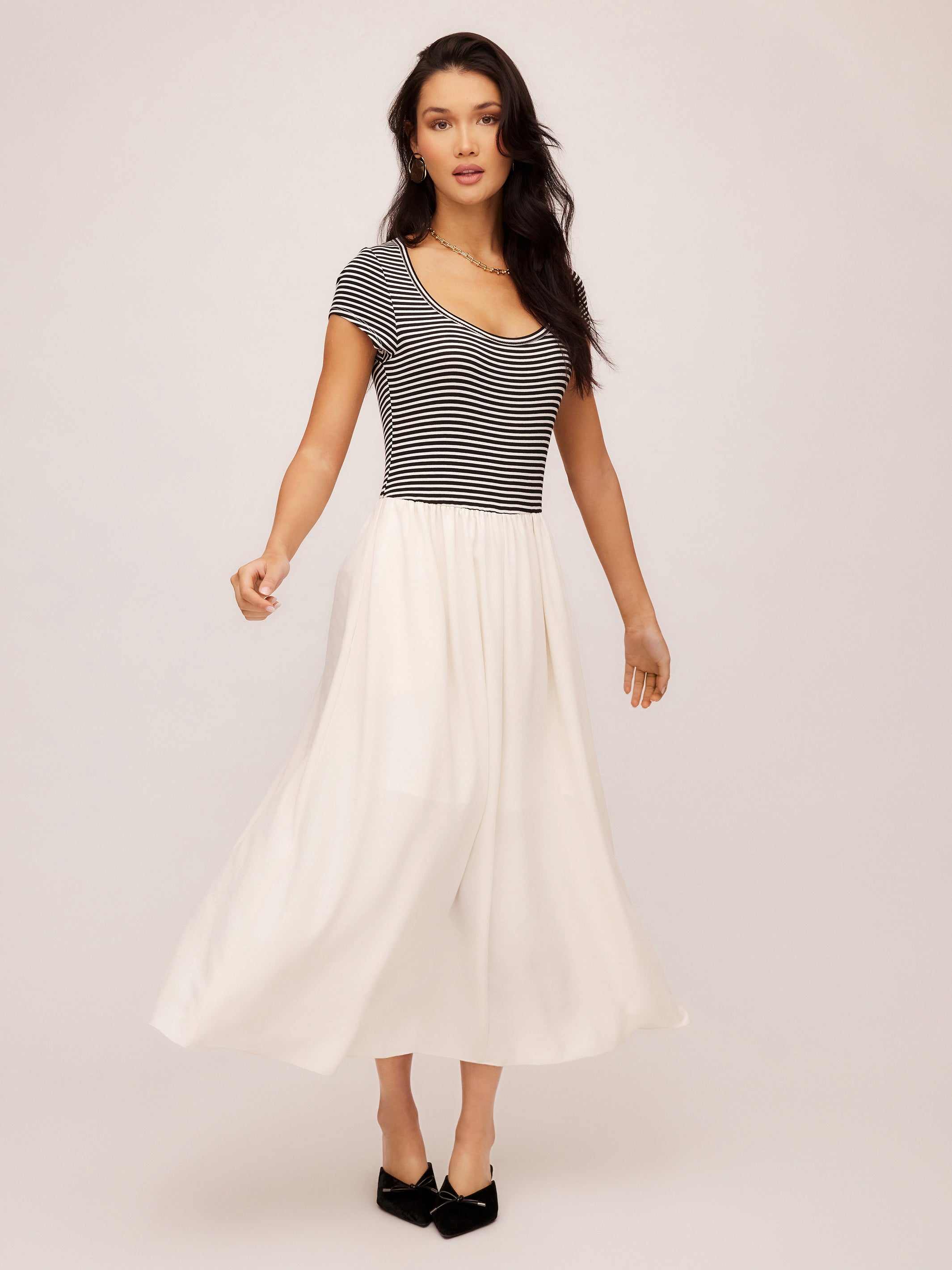 Woman wearing Contrast Hem Sylvie Dress with black and white striped top and flowing white skirt.