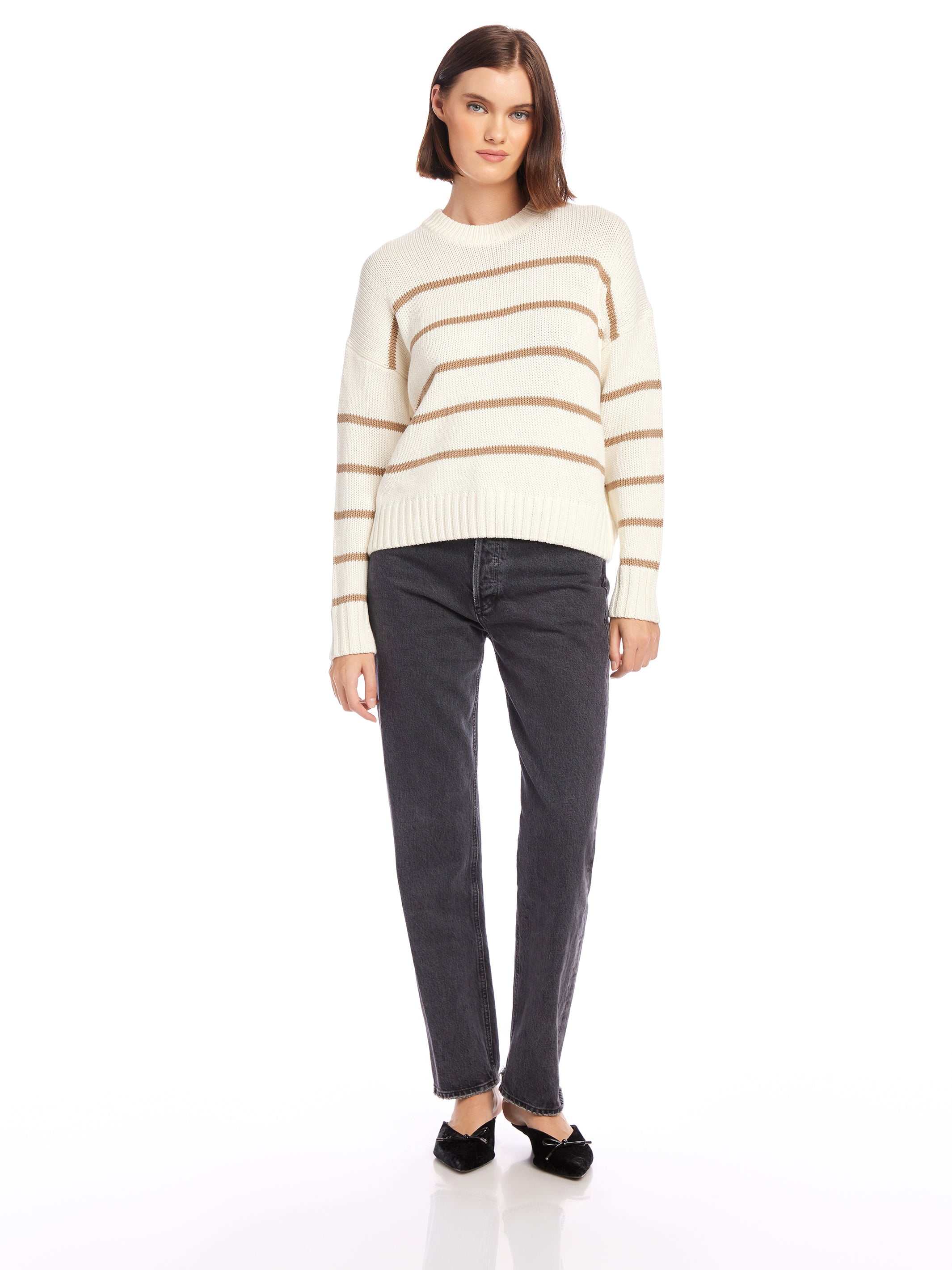 Woman wearing Luca Crewneck Sweater in white with beige stripes and black jeans