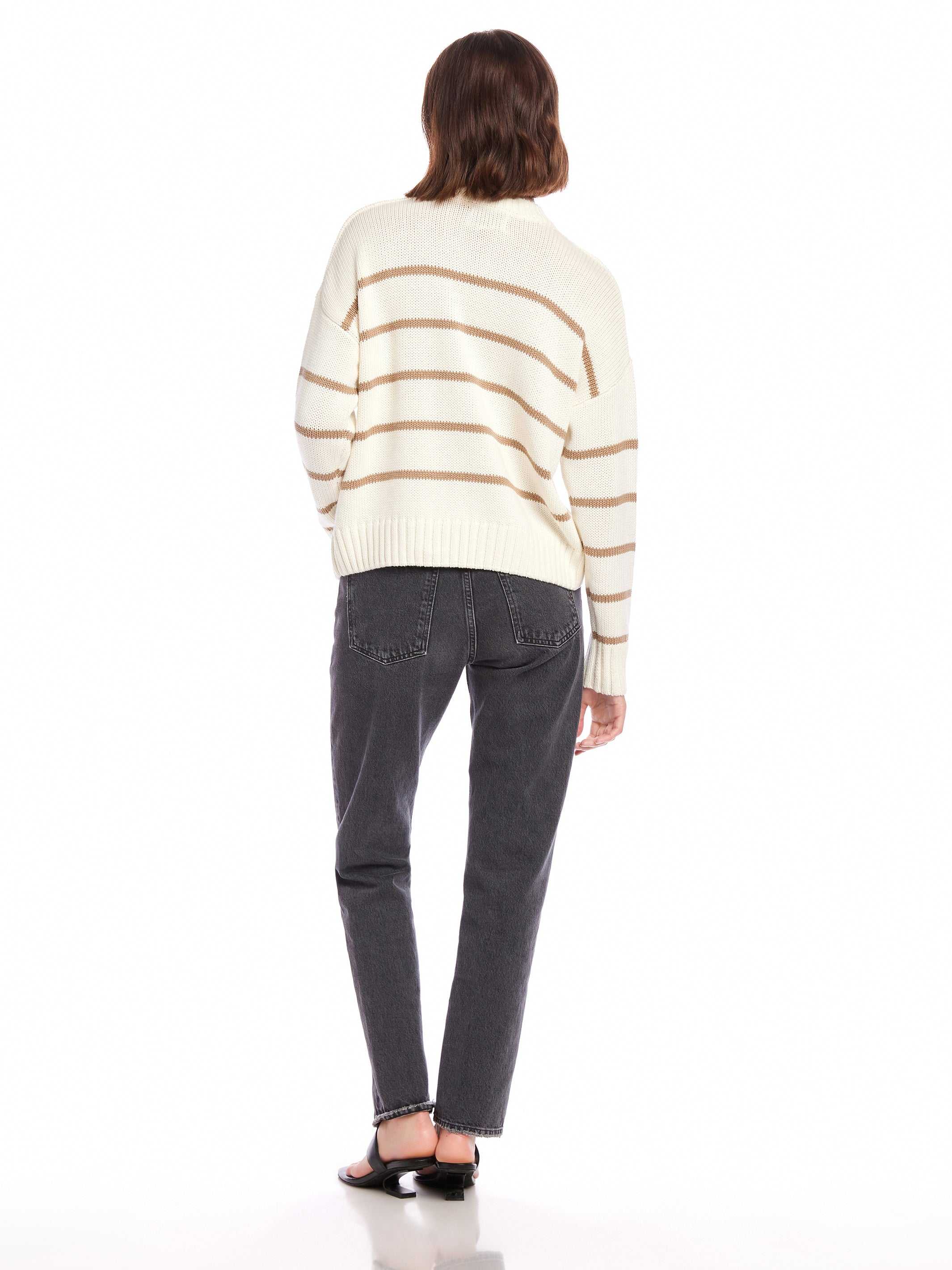 Woman wearing Luca Crewneck Sweater with beige stripes, paired with black jeans and sandals, back view