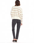 Woman wearing Luca Crewneck Sweater with beige stripes, paired with black jeans and sandals, back view