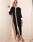 Woman wearing black and white button-down Maves Dress with front slit and long sleeves in cozy sweater material