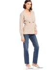Woman wearing Lucy Cardigan with double-breasted buttons and wide cuffs paired with blue jeans and silver heels