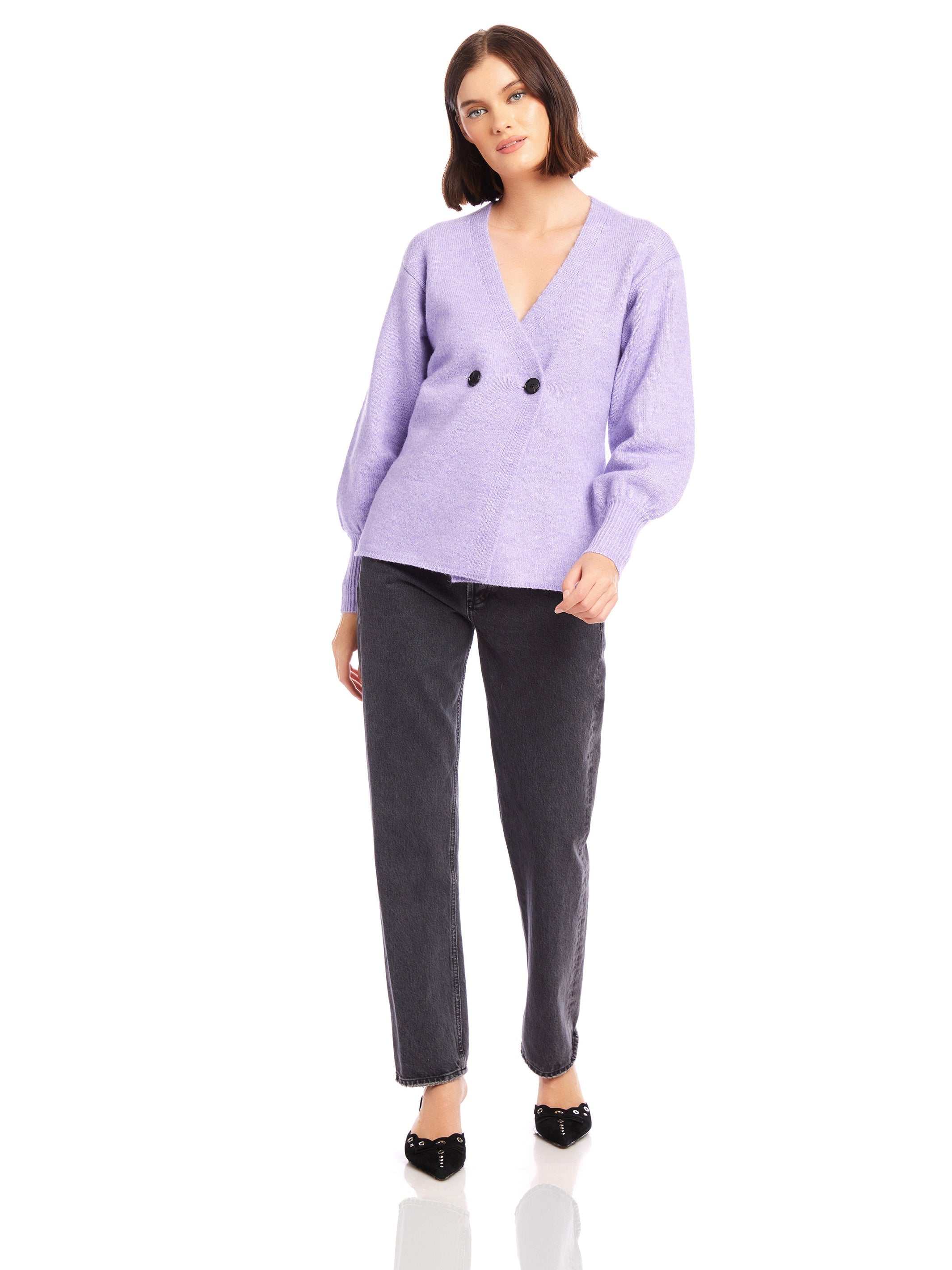 Woman wearing lavender Lucy Cardigan with double-breasted buttons, wide cuffs, V-neck, and long blouson sleeves paired with black jeans.