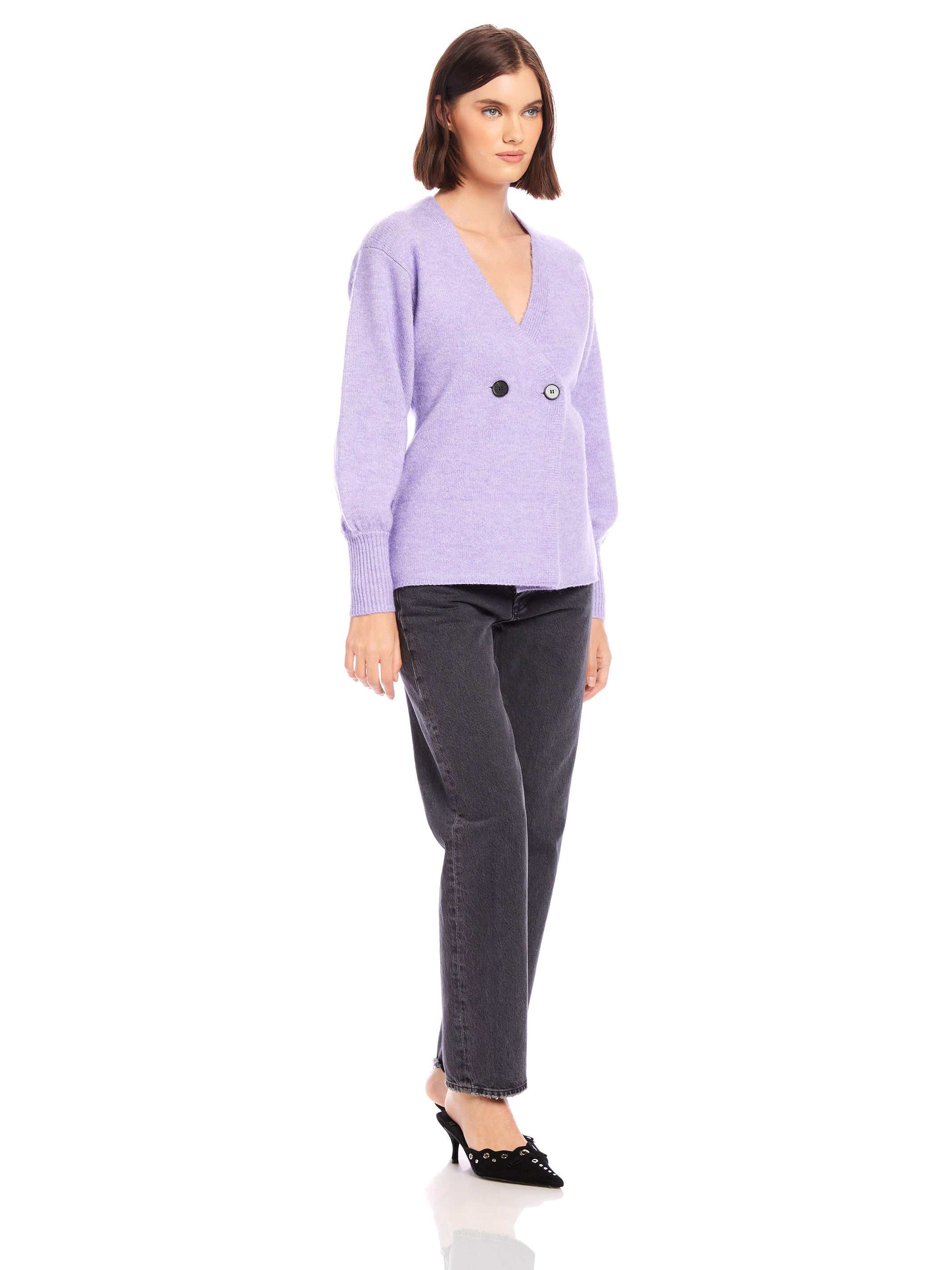 Woman wearing lavender Lucy Cardigan with V-neck, double-breasted buttons, wide cuffs, and long blouson sleeves paired with black jeans and heels