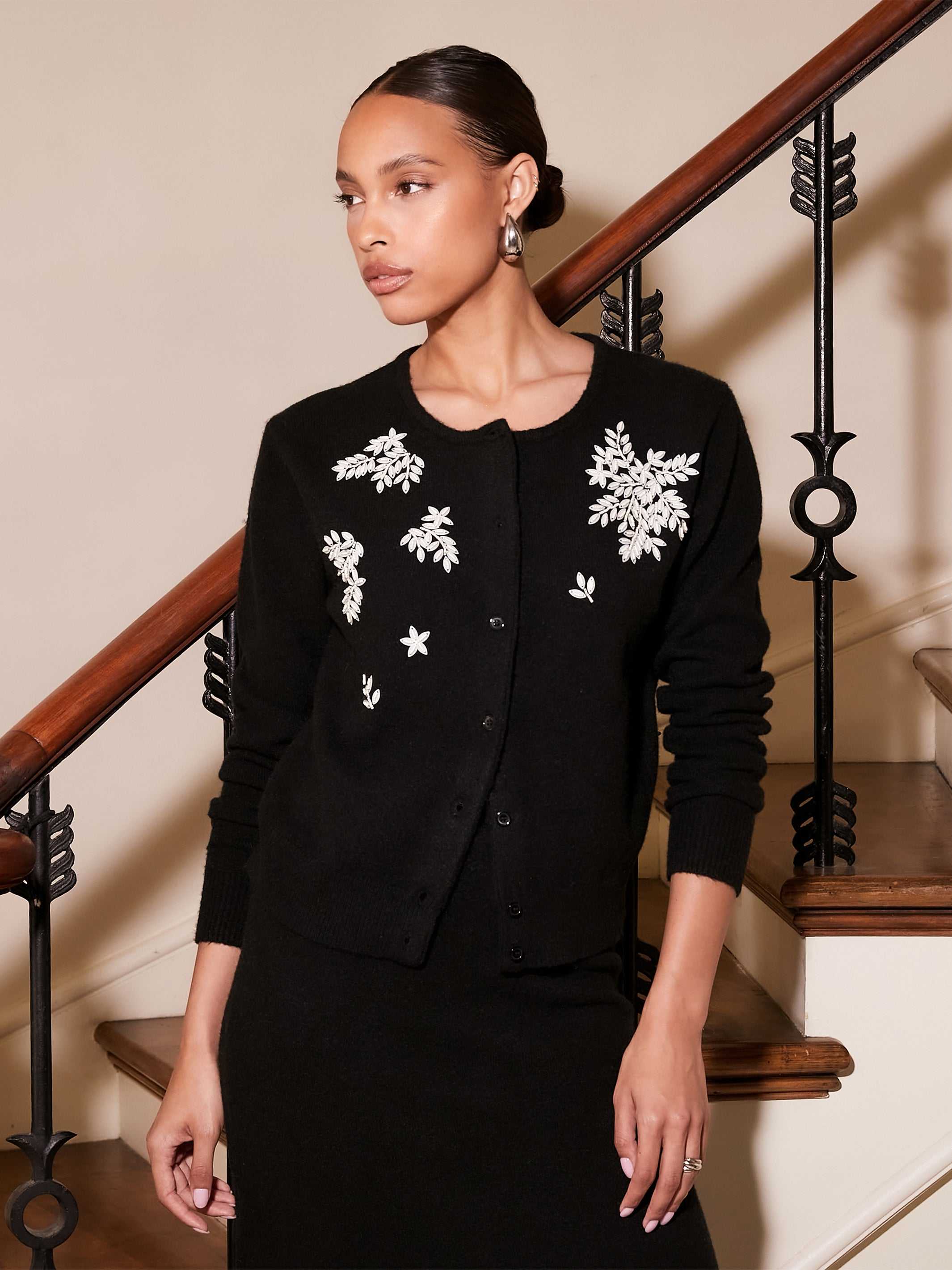 Black Bree Embellished Cardigan with beaded white leaf embroidery, round neck, button front, and long sleeves.