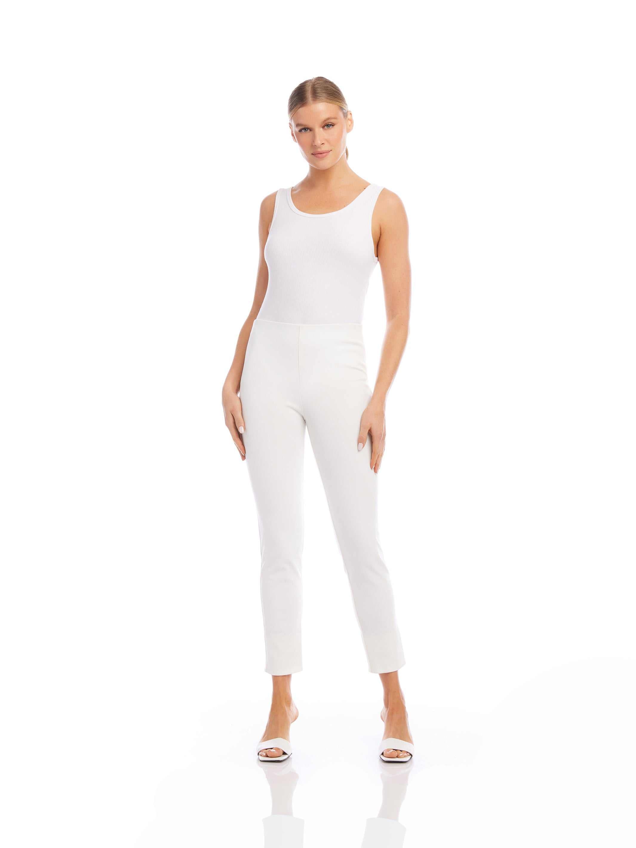 Woman wearing white ankle slit pant with a sleeveless white top and white heels