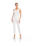Woman wearing white ankle slit pant with a sleeveless white top and white heels