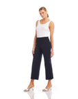 Woman wearing navy wide-leg cropped pants with elastic waistband and white tank top