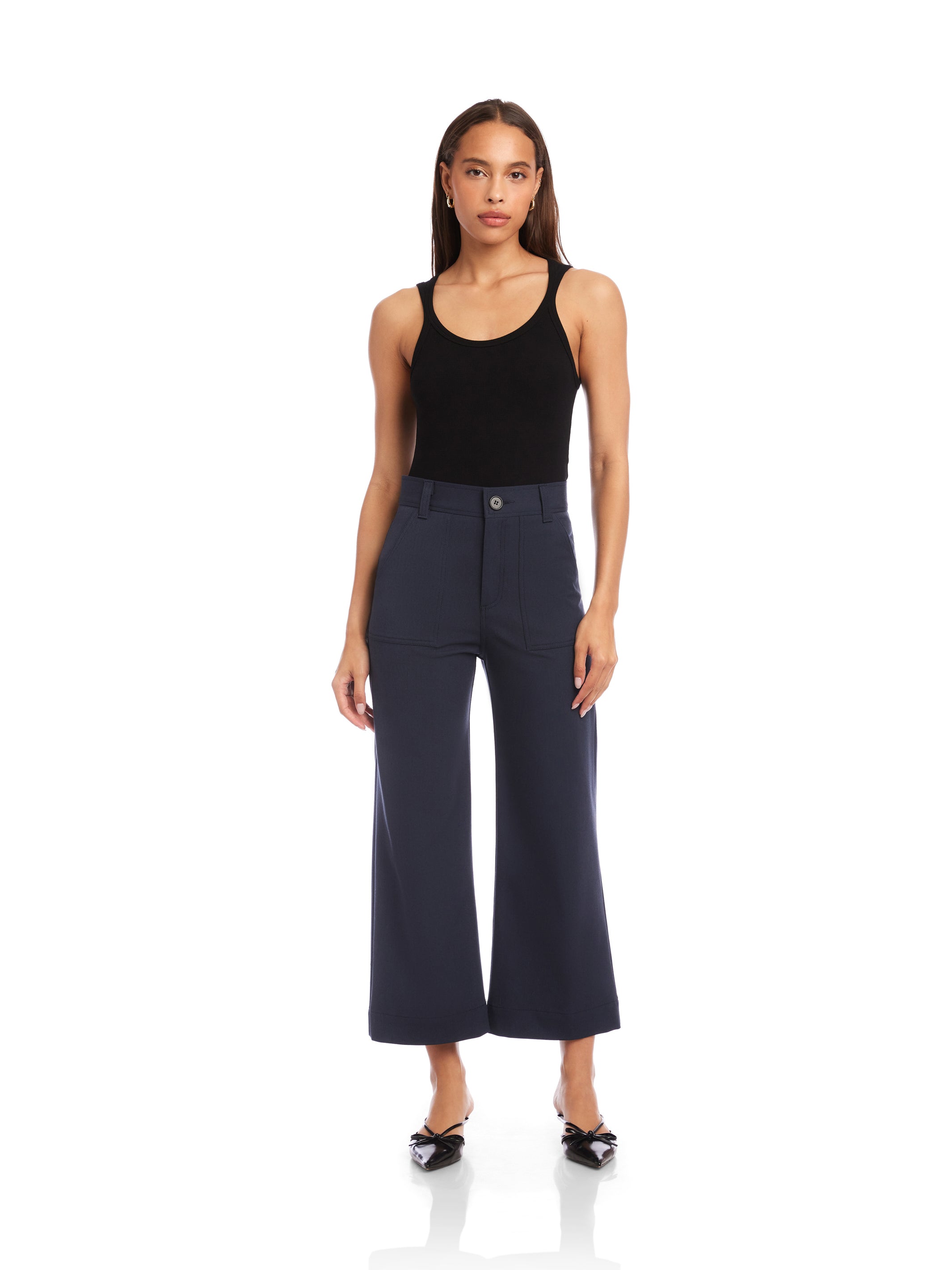 Woman wearing navy blue Rylee Crop Pants with wide legs and cuffed hems paired with a black tank top