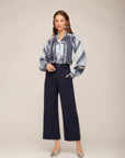Woman wearing navy Rylee Crop Pants with wide-leg cropped fit and button-zipper closure