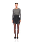 Woman wearing gray bamboo rib knit long sleeve side shirred top with black skirt