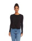 Black long sleeve twist front top in bamboo rib knit worn with jeans