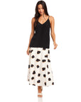 Woman wearing black Carys Silk Cami with adjustable spaghetti straps and V-neck paired with a white patterned skirt