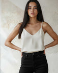 Woman wearing Carys Silk Cami with adjustable straps and V-neckline in cream