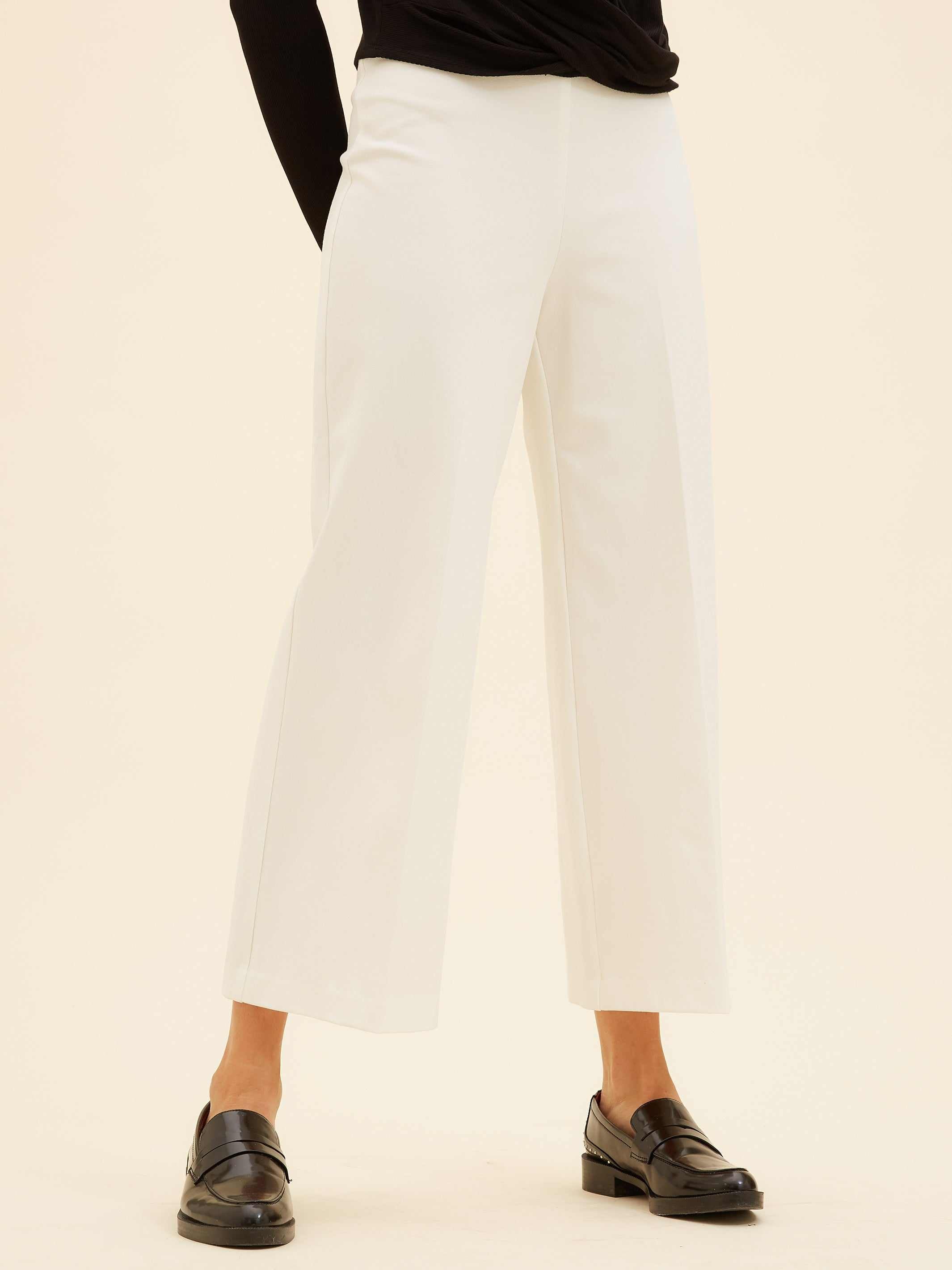 White wide-leg cropped pants made from stretchy viscose blend with elastic waistband and relaxed fit.