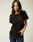 Woman wearing black basic short sleeve tee with crew neck and straight hem paired with blue jeans