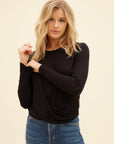 Woman wearing black long sleeve twist front top with bamboo rib knit and jeans