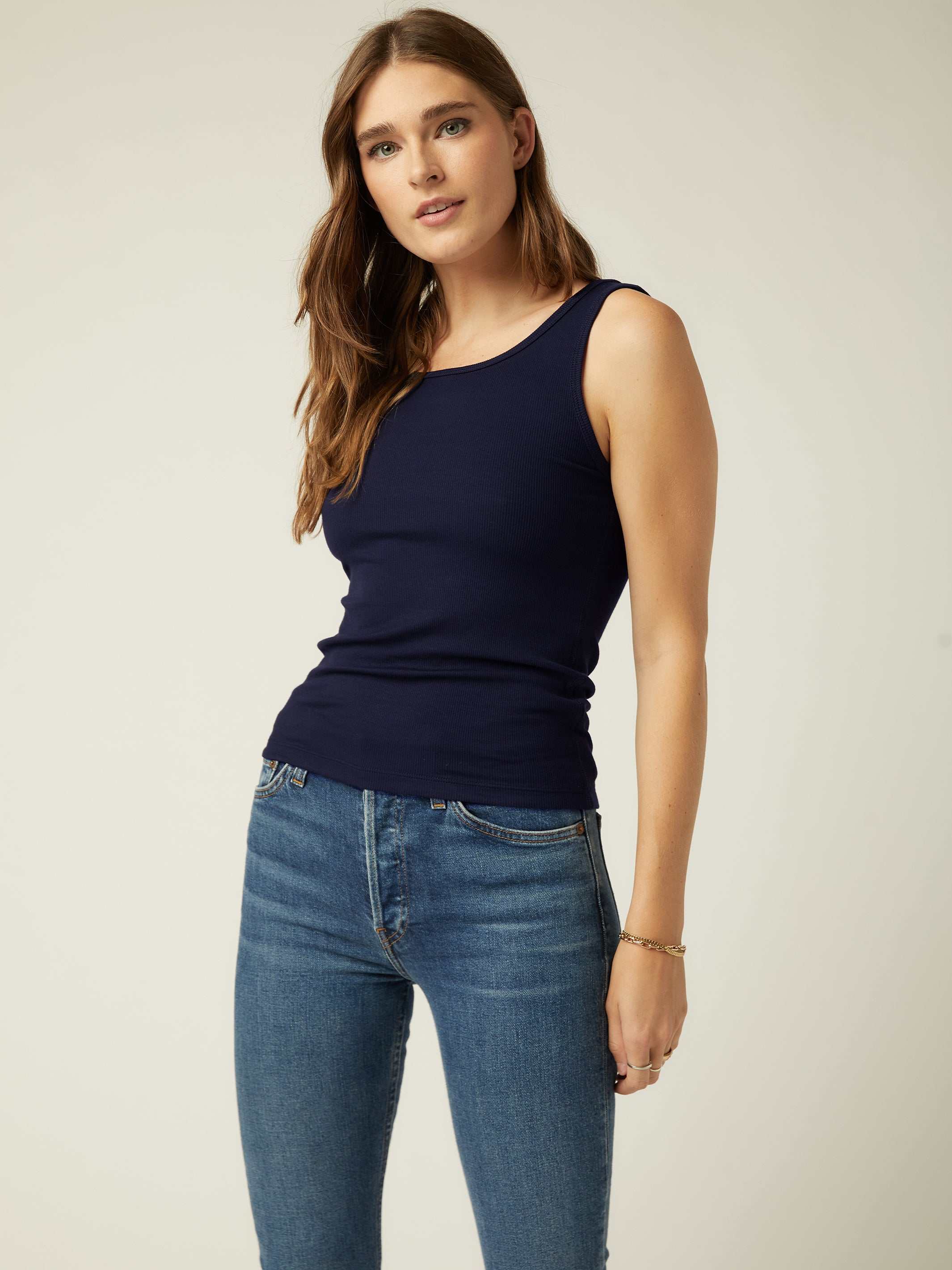 Woman wearing a navy sleeveless rib-knit Everyday Rib Tank with scoop neck and straight hem paired with blue jeans