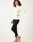 Woman wearing white brushed rib-knit long sleeve turtleneck with black pants and beige ankle boots