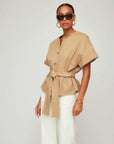 Woman wearing a Kai Belted Button-Up Top with short cuffed sleeves and tortoise buttons